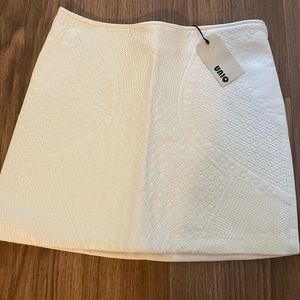 Small, white/cream, mini skirt with quilted design in a faux leather front
